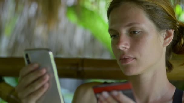 Женщина в отеле курорт шопинг онлайн с кредитной картой, банкинг со смартфоном. Телефон-автомат — стоковое видео
