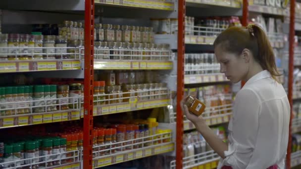 Бали, Индонезия - март 2019 года: женщина выбирает еду в банке в супермаркете. женские консервы для чтения . — стоковое видео
