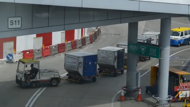 Hongkong, China - agosto 2019: Carro pequeno com carrinhos para bagagem dirigindo no aeroporto de hong kong, transporte de bagagem de carga . — Vídeo de Stock