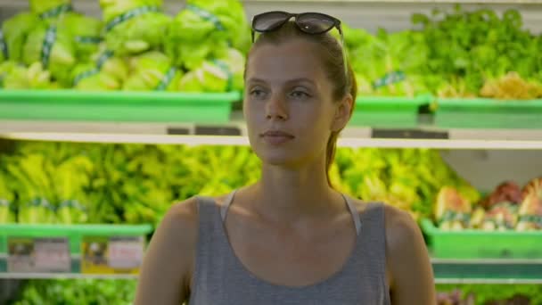 Jeune femme aux cheveux roux attrayante posant dans la section biologique du supermarché pendant le temps de magasinage . — Video