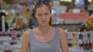 Güzel genç bayan süpermarkette gülümseyen kameraya bakıyor. Kadın portresi