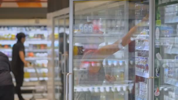 Jonge vrouw reiziger kopen yoghurt en wandelen in de supermarkt tijdens Aziatisch reizen. — Stockvideo