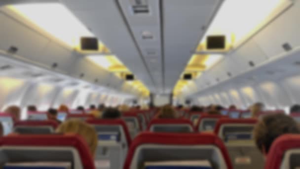 Defocus Men and women passengers sitting in interior of plane during flight on traveling. — Stock Video