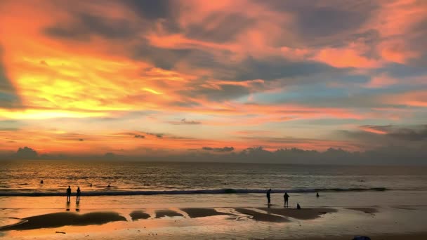 観光客は島の夕日の間に海辺で時間を過ごしています. — ストック動画