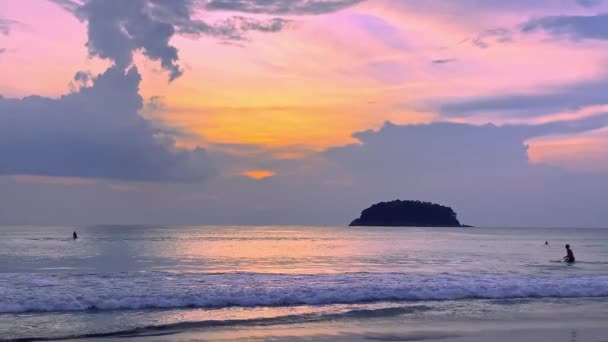 エキゾチックな島の日没の間に海でサーフィンする美しい自然景観と人々. — ストック動画