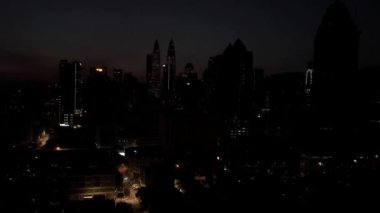 Kuala Lumpur, Malezya - 15 Mart 2019: Petronas İkiz Kuleleri etrafındaki Kuala Lumpur siluetinde gün doğumunun hızlandırılması. Kuala Lumpur, Malezya 'daki yüksek binaların hava görüntüleri