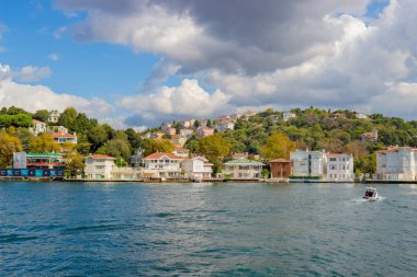 İstanbul, Türkiye - 6 Ekim 2019: İstanbul, Türkiye 'de İstanbul Boğazı' nın su kenarında parlak evler bulunan güneşli manzara