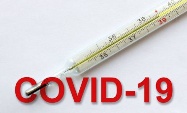 Geleneksel tıbbi cıvalı cam termometre higth sıcaklığını 39 C vücut ve beyaz arka planda kırmızı COVID 19 yazısını gösteriyor. Yüksek sıcaklık, koronavirüs enfeksiyonunun bir belirtisidir.