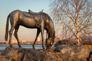 Krasnoyarsk, Rusya - 12 Nisan 2020: Yenisei Nehri 'nin kıyısındaki öncü Andrei Dubensky' nin onuruna dikilmiş işlenmiş demirden yapılmış 'Beyaz At' anıtının gün batımı manzarası