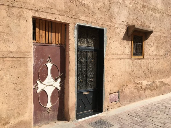 モロッコのマラケシュのメディナ地区にある質感のテラコッタ製の石壁を持つ古い鉄の扉 選択的焦点 — ストック写真