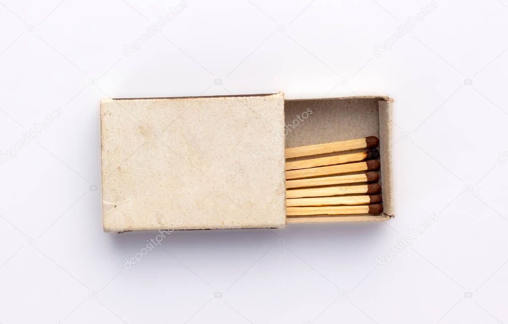 Opened old box of matches isolated on white background, top view. One burnt wooden match among the new ones. Space for design on cardboard box.