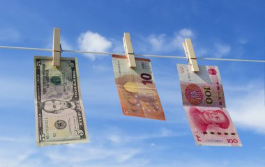 Euro, China Yuan ve Amerikan doları banknotları mavi gökyüzündeki ahşap mandallarda asılı. Para aklama konsepti. Ticaret savaşı.
