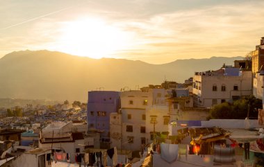 Fas 'ın Chefchaouen kasabasında gün batımı parlıyor. Mavi şehrin Medine 'sinin çatıları sıcak renklerde. Kuzey Afrika 'ya seyahat