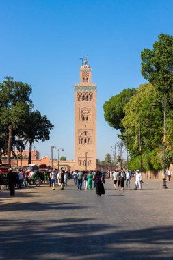 Marakeş, Fas - 12 Ekim 2019: Jamaa el-Fna Bulvarı. Koutoubia Camii 'nin minaresine bakın. Medine 'de turistler ve yerliler yürüyor