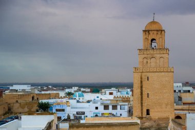 Kairouan, Tunus - 28 Ekim 2019: Kairouan Büyük Camii 'nin Minaresi' ne akşam manzarası ve Tunus 'un eski Medine semtinin beyaz çatıları