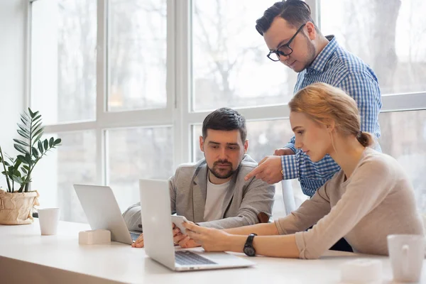 team of three coworkers in stylish studio