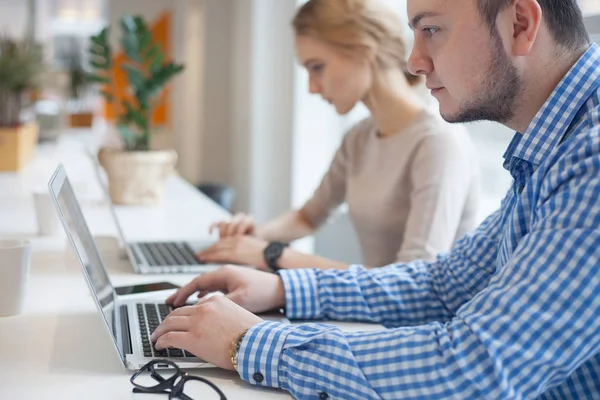 Üç kişilik bir ekip şık bir stüdyoda çalışıyor.