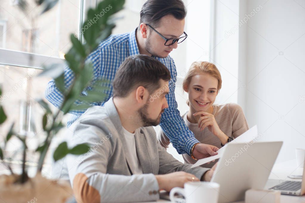 team of three coworkers in stylish studio