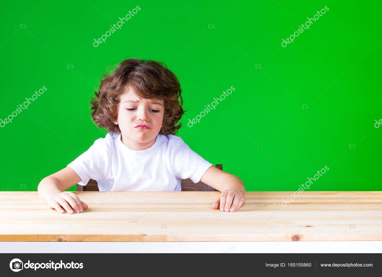The Curly Haired Pretty Boy Sticking Out His Mouth Sitting At A