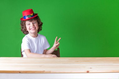 Palyaço şapka gülüyor içinde sevimli kıvırcık saçlı çocuk 