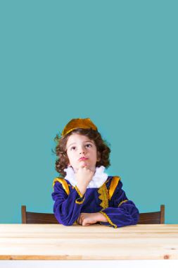 Küçük Prens çok üzgün görünüyor. Yakın çekim. Turkuaz arka plan.