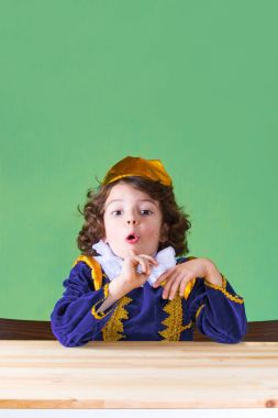 Genç yakışıklı prens openmouthed kameraya bakıyor. Yakın çekim. Yeşil arka plan.