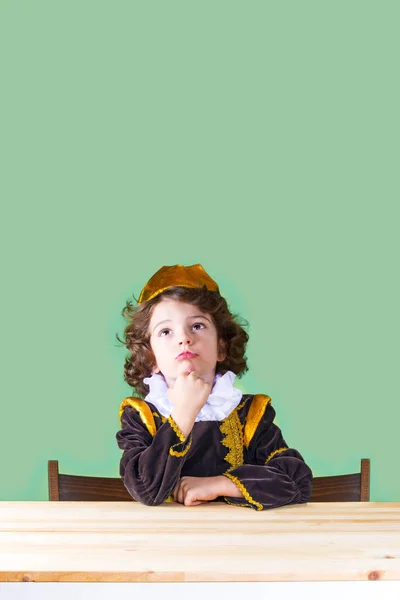 Genç üzücü Prens dikkatle baktı. Yakın çekim. Yeşil arka plan.