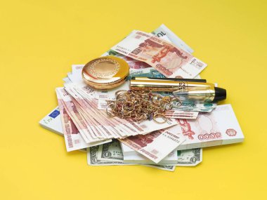 Altın takı ve makyaj Lirası üstünde öğelerdir. Sarı arka plan.