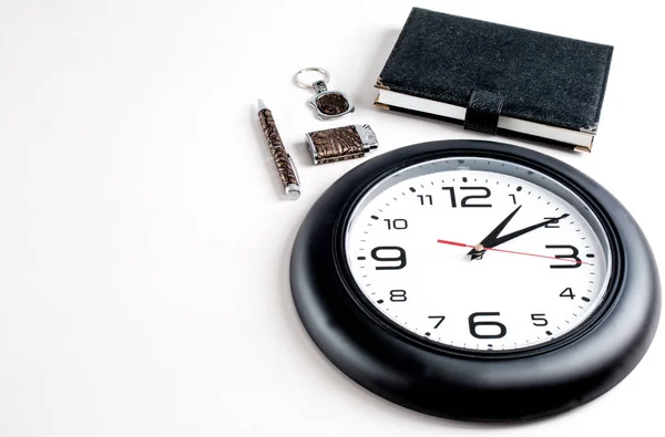 Collage. Más ligero, llavero, bloc de notas y bolígrafo se encuentran junto al reloj. Fondo blanco . — Foto de Stock