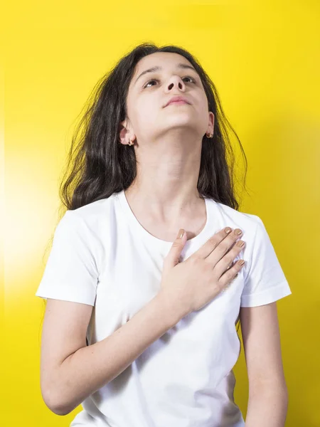 Young woman swears or promises. Yellow background — Stock Photo, Image