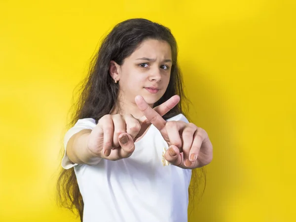 Mooie brunette meisje cross haar armen te tonen gebaar niet geïsoleerde over geel — Stockfoto