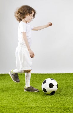 Futbol topu gri bir arka plan üzerinde çocukla.