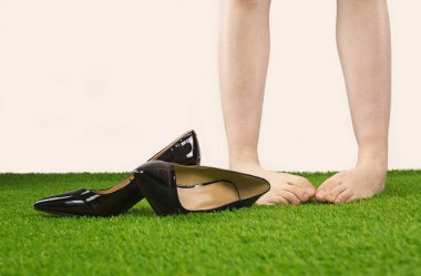 Genç kadın götürdüm ayakkabılar için sakin ol çimenlerin üzerinde alt bacaklar yakın çekim, erkek aldı yüksek topuklu ayakkabısını fırlatıp.