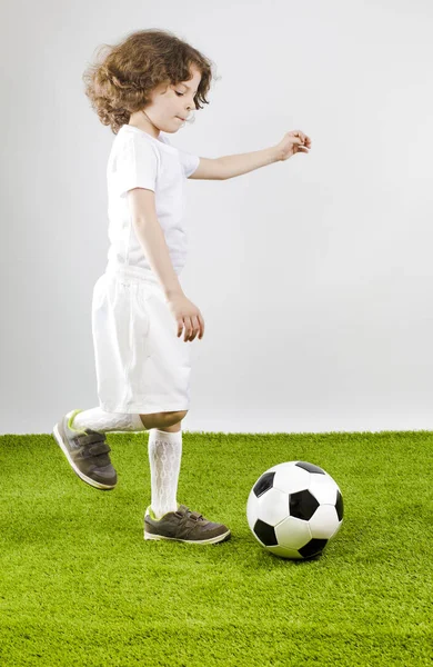 Futbol topu gri bir arka plan üzerinde çocukla.