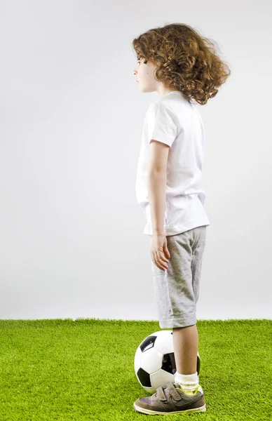 Futbol topu gri bir arka plan üzerinde çocuk. Yan görünüm