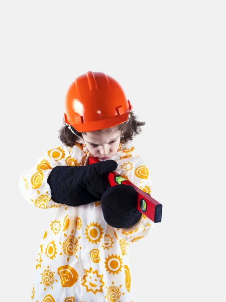 건물 레벨 비옷에 재미 있는 곱슬 머리 소년 빌더. 오렌지 건설 헬멧 및 건설 장갑 포먼... 회색 배경. — 스톡 사진