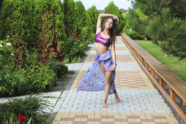 Yeşil ağaçlar sokak ve mutlu genç kız kameraya poz güzel manzara. Yaz aylarında muhteşem park. Manzara kadın, ağaçlar, Yeşil çimenler, yolu ile. Yaşam tarzı arka plan.