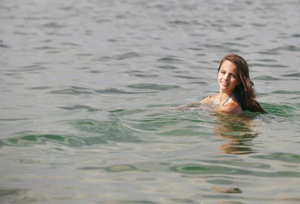 Belle femme nageant dans la mer en vacances d'été. Arrière-plan avec espace pour texte ou image . — Photo