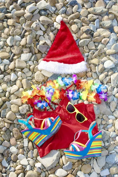 Strandurlaub Weihnachtsmann-Artikel liegen an der steinigen Küste — Stockfoto