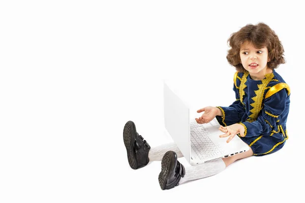A képet egy fiatal kaukázusi fiú sokk/elkeseredés ül egy laptop. Ő van öltözve, mint egy király — Stock Fotó