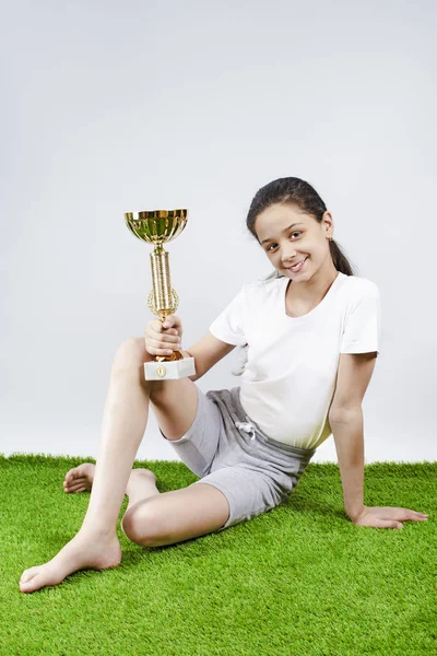 A happy sweet girl holding a gold cup. — Stock Photo, Image