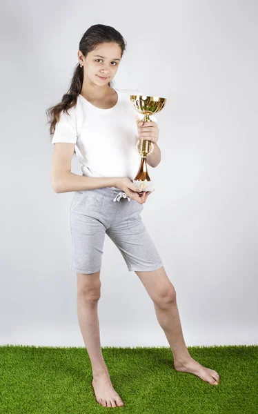 A happy sweet girl holding a gold cup. — Stock Photo, Image