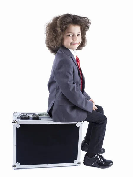 Kleiner Junge sitzt auf Koffer und bereitet sich auf den Urlaub vor. Geschäftsmann, fröhliches aktives Kind. Reisen. weißer Hintergrund — Stockfoto