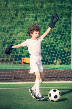 Küçük çocuklar için yaz futbol turnuvası. Futbol kulübü. Oyunun heyecanı ve neşesi. Genç kaleci. Çocuklar, futbol şampiyonu. Stadyumda futbol takımının erkek kalecisi. Spor konsepti.