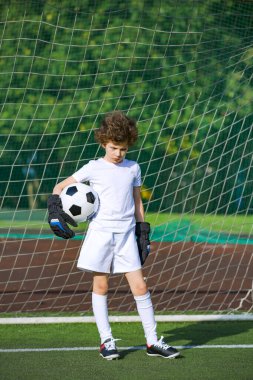 Çocuklar futbol şampiyonudur. Futbol takımının kalecisi. Stadyumun müthiş bir manzarası var. Atletik ve atletik öfke konsepti.