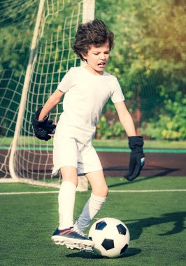 Küçük çocuklar için yaz futbol turnuvası. Futbol kulübü. Oyunun heyecanı ve neşesi. Genç kaleci. Çocuklar, futbol şampiyonu. Stadyumda futbol takımının erkek kalecisi. Spor konsepti.