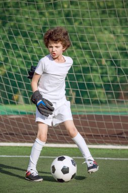 Küçük çocuklar için yaz futbol turnuvası. Futbol kulübü. Oyunun heyecanı ve neşesi. Genç kaleci. Çocuklar, futbol şampiyonu. Stadyumda futbol takımının erkek kalecisi. Spor konsepti.