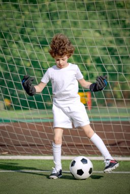 Küçük çocuklar için yaz futbol turnuvası. Futbol kulübü. Oyunun heyecanı ve neşesi. Genç kaleci. Çocuklar, futbol şampiyonu. Stadyumda futbol takımının erkek kalecisi. Spor konsepti.
