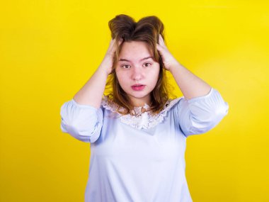 Genç, stresli bir kadın baş ağrısı çekiyor ve elleriyle başını tutuyor. Öğrenci kız sorununu çözmeye çalışıyor. Çıkış durumu yok.