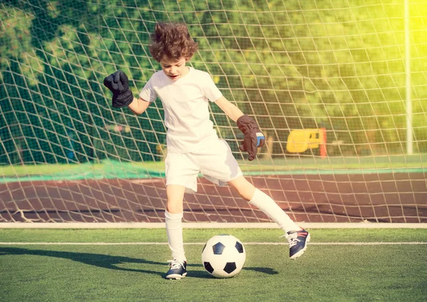 Torneo de fútbol de verano para niños pequeños. club de fútbol. emociones y alegría del juego. Joven portero. Niños - campeón de fútbol. Niño portero en ropa deportiva de fútbol en el estadio con pelota. Concepto deportivo . — Foto de Stock